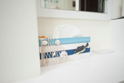 a shelf in a white room with a mirror at 台南樂河民宿 in Tainan