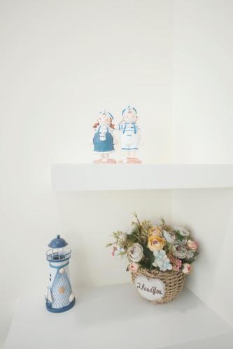 a shelf with a basket of flowers and a candle at 台南樂河民宿 in Tainan