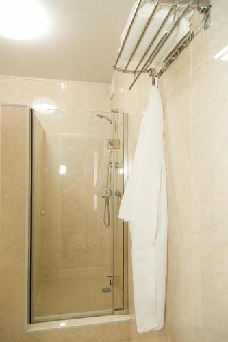 a bathroom with a shower and a towel on a rack at Mirage Hotel in Qyzylorda
