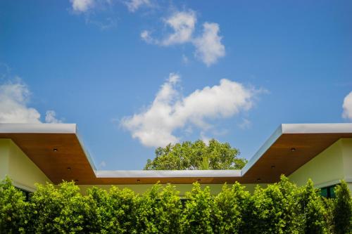 a view of a building with a tree in the sky at Good Night Pool Villa Phuket - SHA Plus in Phuket Town
