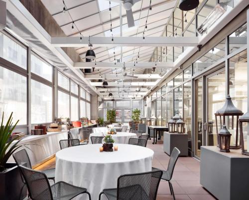 a large room with tables and chairs and windows at Hyatt Centric Times Square New York in New York