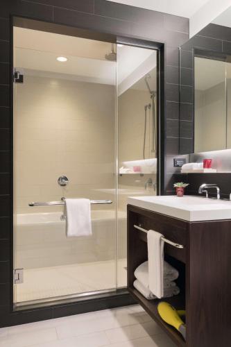 a bathroom with a glass shower and a sink at Hyatt Centric Times Square New York in New York