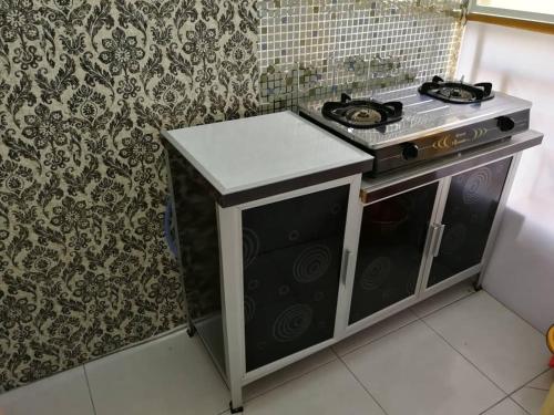 a kitchen with a stove top oven in a room at A1-04-03 Damiana Apartment in Tanjung Malim