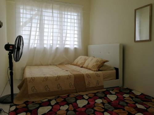 a bedroom with a bed with a window and a rug at A1-04-03 Damiana Apartment in Tanjung Malim