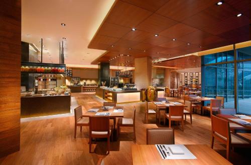 a restaurant with tables and chairs and a bar at Hyatt Regency Guiyang in Guiyang