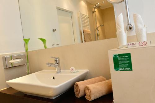 a bathroom with a sink and a refrigerator at Hotel Uhu Garni - Superior in Cologne