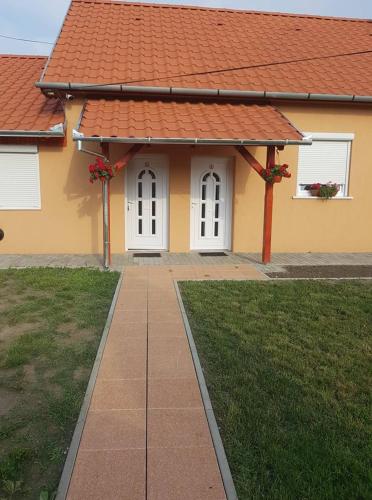 a house with an orange roof and a walkway at Boróka Vendégház Túrkeve in Túrkeve