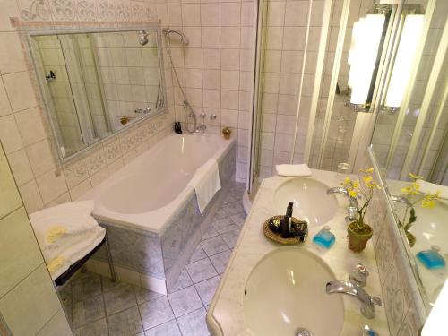 a bathroom with a tub and a sink and a bath tub at Hôtellerie Du Bas-Bréau in Barbizon