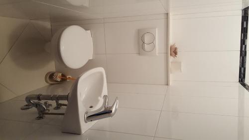 a white bathroom with a sink and a mirror at Apartments Galic Omis in Omiš