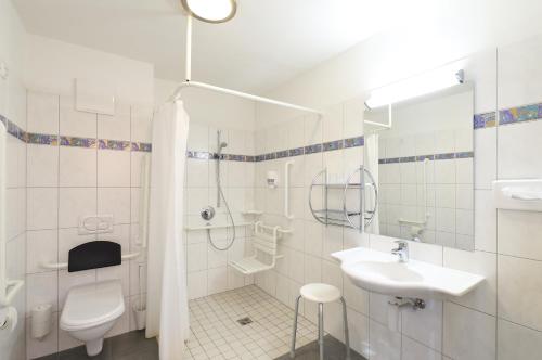 a white bathroom with a toilet and a sink at Gasthaus-Landhotel Traunstein in Abtenau