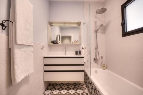 a bathroom with a tub and a sink and a shower at Yohanan HaSandlar in Tel Aviv