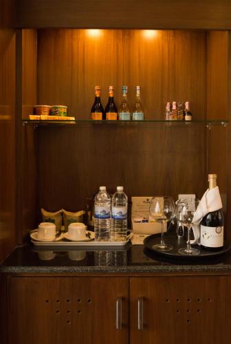 a kitchen with a table with glasses and bottles of alcohol at Park Village Resort by KGH Group in Kathmandu