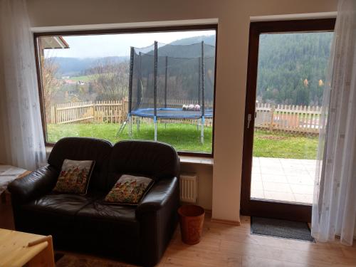 a living room with a couch in front of a window at Ferien Paradies in Baiersbronn