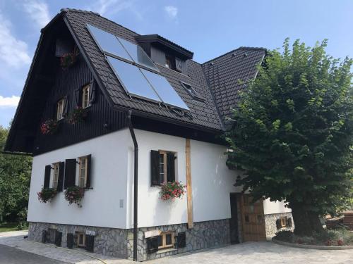a black and white house with windows and a tree at Rustic Inn River 2 in Plitvička Jezera