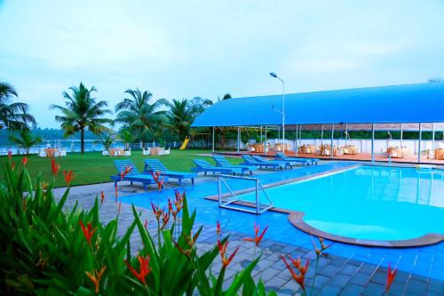 une grande piscine avec des chaises et un bâtiment dans l'établissement Blue Waters Cherai, à Cherai Beach