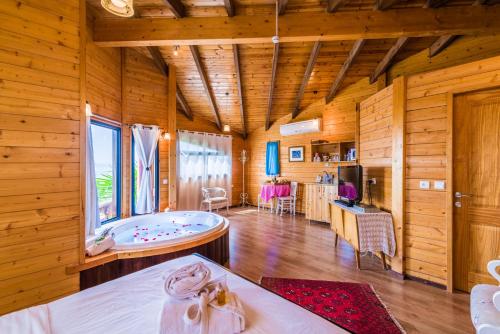 een kamer met een bad in een houten kamer bij Nof Tzameret Cabins in Kahal