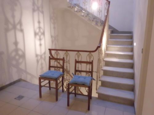 two chairs sitting next to a stair case with stairs at Hotel Paolina in Viareggio