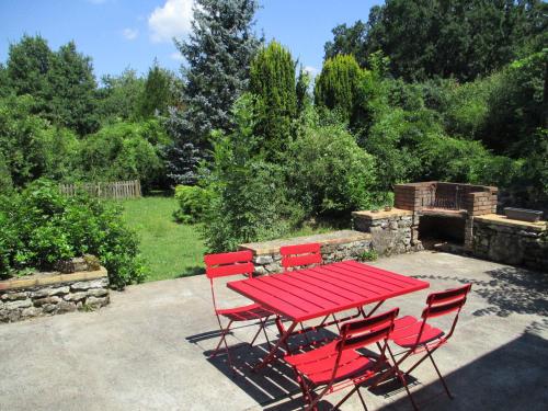 a red picnic table and chairs in a garden at "Le Jardin de Zola", Longère XIXème en BOURGOGNE, grand jardin in Lurcy-le-Bourg