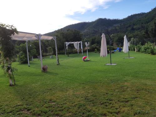 a park with umbrellas and a ball in the grass at B&B Le Stanze del Moro in Pállare