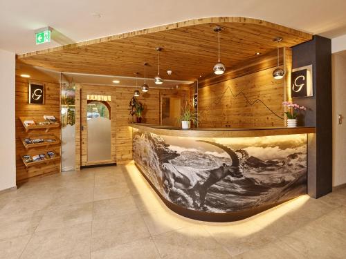 a lobby with a large painting on the wall at Hotel Gundolf in Sankt Leonhard im Pitztal