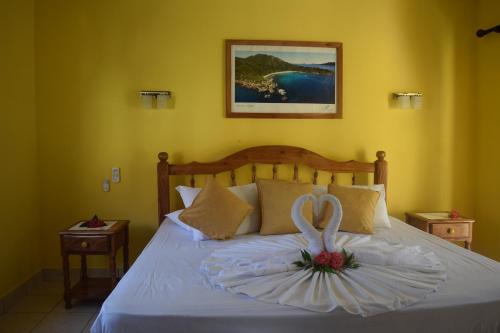 a bedroom with a bed with a white flower on it at Pension Citadelle in La Digue