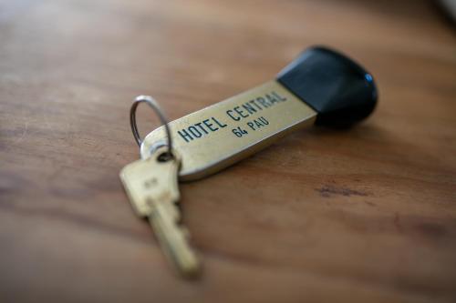 a small metal key on top of a wooden table at Hôtel Central in Pau