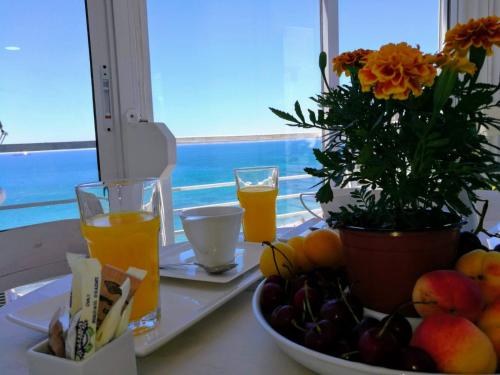 a table with a plate of fruit and two glasses of orange juice at Grandpa Beach House in Alicante