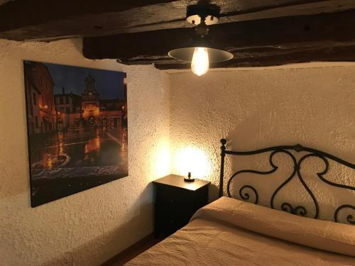 a bedroom with a bed with a lamp and a picture at La Casetta ai Lavatoi di Sutri in Sutri