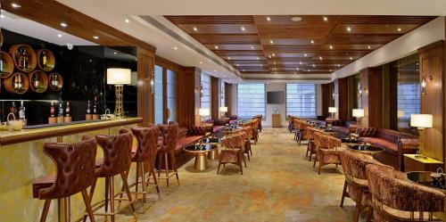 a bar with a row of chairs and tables in a room at Radisson Chandigarh Zirakpur in Chandīgarh