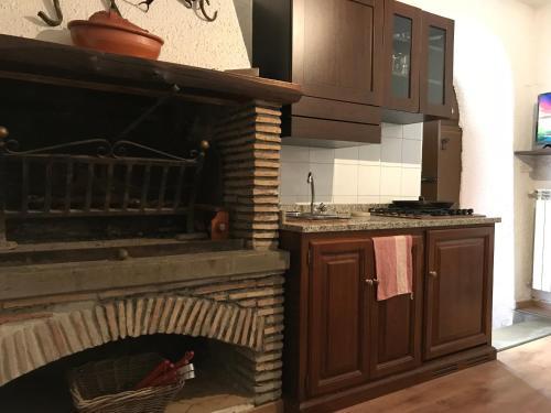a kitchen with a brick fireplace in a kitchen at La Casetta ai Lavatoi di Sutri in Sutri