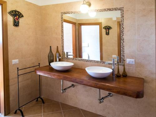 a bathroom with two bowls on a wooden counter in front of a mirror at Il Sestante in Civitanova Marche