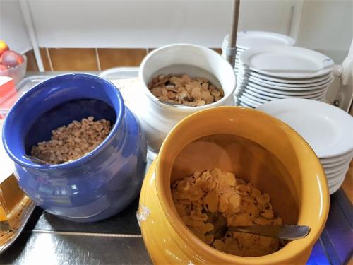 un comptoir avec des bols de nourriture et des assiettes dessus dans l'établissement Hotel Marina Playa De Palma, à El Arenal