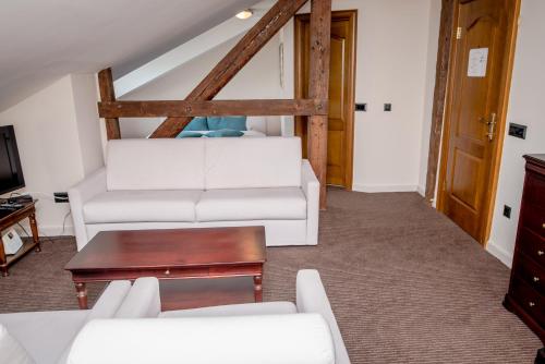 a living room with a white couch and a table at Hotel Astoria in Tivat