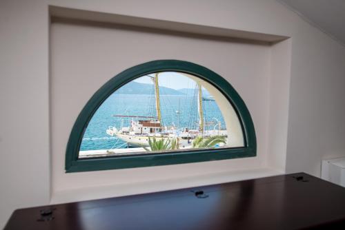 a window in a wall with a boat in the water at Hotel Astoria in Tivat