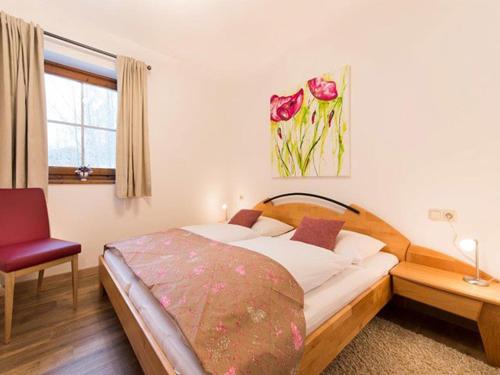 ein Schlafzimmer mit einem Bett, einem Stuhl und einem Fenster in der Unterkunft Haus Christoph in Maria Alm am Steinernen Meer