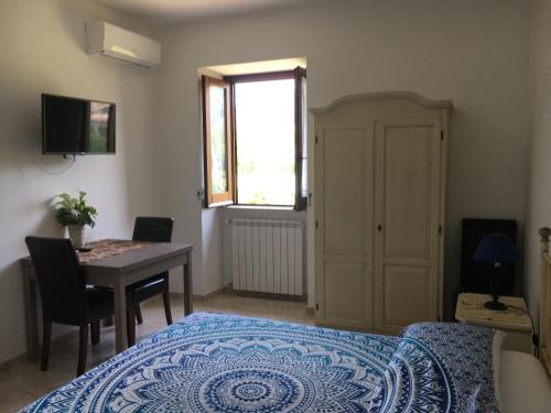1 dormitorio con cama, mesa y ventana en Maison de Charme Iommella, en Sant'Agnello