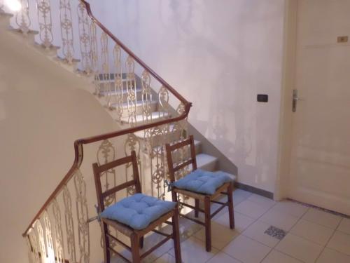 two chairs with blue cushions sitting next to a staircase at Hotel Paolina in Viareggio