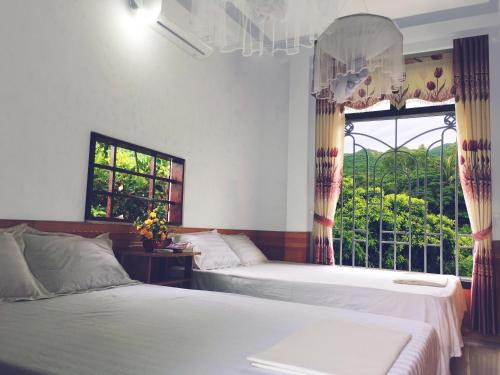 - une chambre avec 2 lits et une fenêtre dans l'établissement Trang Vu Homestay Cu Lao Cham, à Tân Hiệp