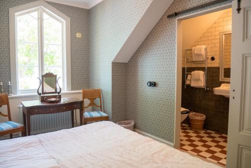 a bedroom with a bed and a bathroom at Warfsholm in Klintehamn