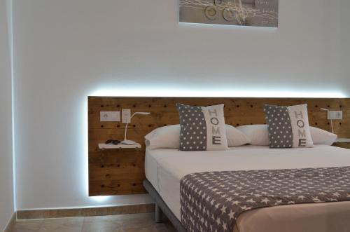1 dormitorio con 1 cama con cabecero de madera en Arkadia Apartaments 2.2, en Roses