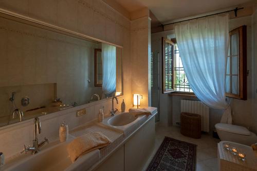 bagno con vasca, lavandino e specchio di Villa Brama a Legnago