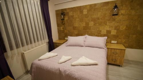 a bedroom with a bed with two pillows on it at Castle Nolana in Geredeli