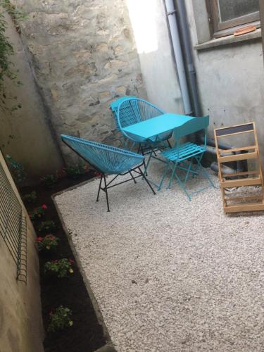 a blue table and chairs on a patio at F2 cosy avec Cour in Milly-la-Forêt