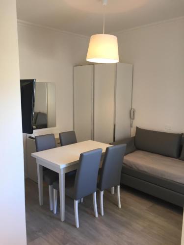 a room with a table and chairs and a couch at Hotel Ardea in Riccione