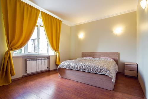 モスクワにあるDream House Plyushchikhaのベッドルーム1室(ベッド1台付)、黄色いカーテン付きの窓が備わります。