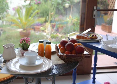 einen Tisch mit einer Schale Obst und einem Teller Essen in der Unterkunft Angolo Verde in Oristano