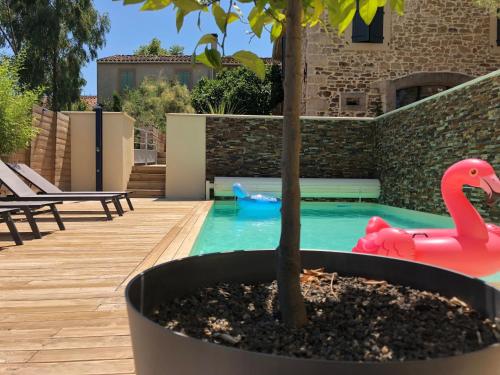 une piscine avec un jouet flamingo et un arbre dans l'établissement La Forge, à Montséret