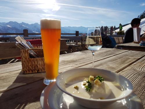 ミッタージルにあるPanorama Chalets am Pass Thurnのスープとビールのグラス1杯