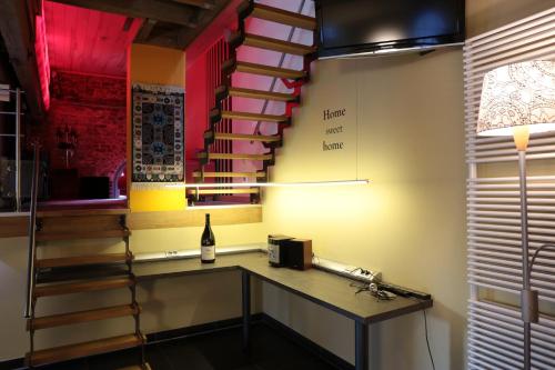 una habitación con una mesa y una escalera con una botella de vino en Blue House On The Water en Kortrijk