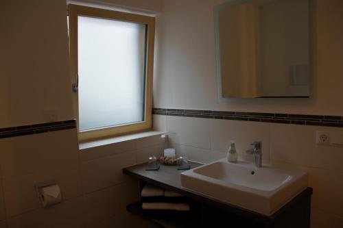a bathroom with a sink and a window at Ferienwohnungen Ellen Müller in Fischen